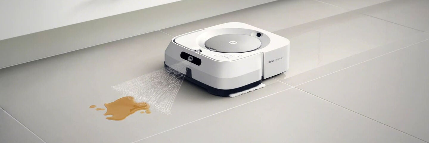 Un robot Braava m6 blanco limpiando líquido del suelo